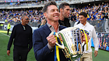 Ben Cousins carries the 2006 Premiership Cup around the field with former teammates in 2026.