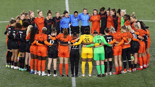 Players and officials from the NWSL’s Portland Thorns and Houston Dash pause for a minute of solidarity during a match last October.