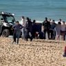 A woman is treated on Coogee Beach after being bitten by a shark.