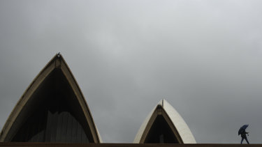 A tourist passes the Sydney Opera House on Sunday.