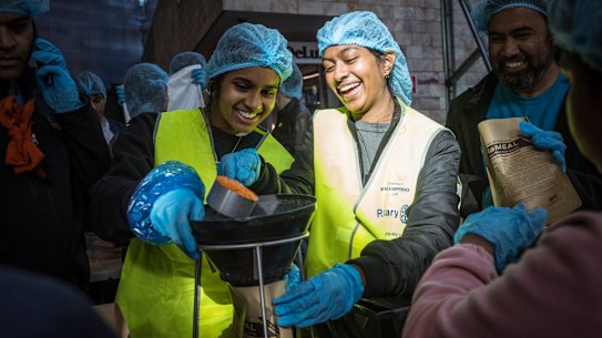 Volunteers Sochini Pryaratne and Nitusha Sathananthan help prepare food care packages.