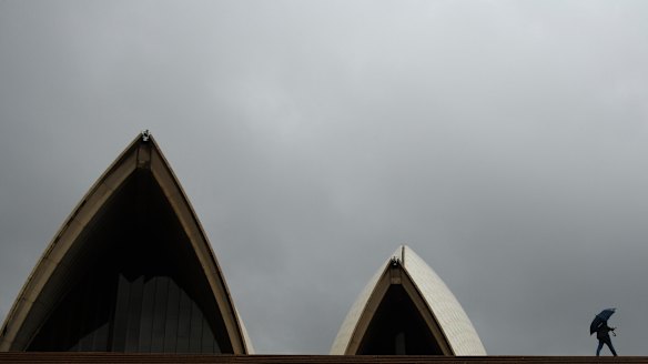 A tourist passes the Sydney Opera House on Sunday.