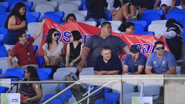 Deregistered player agent Isaac Moses (bottom right, in blue shirt and black cap) sitting with the Suaalii family on Saturday.