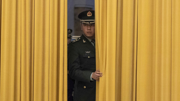 A member of Chinese People's Liberation Army waits for a welcome ceremony to start.