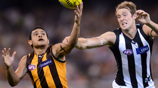 Hawk Cyril Rioli and Magpie Ben Reid battle for possession in 2012.