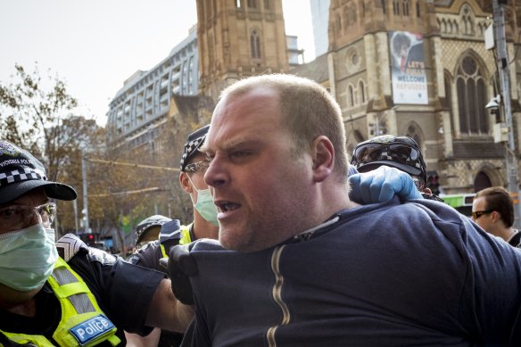 Anti-vaccine protesters are arrested outside Flinders Street Station after hijacking a demonstration of small business owners on Saturday morning. 