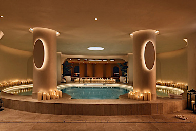 An indoor pool surrounded by lit candles