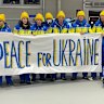 Members of Ukraine’s Paralympic team hold us a sign for peace.