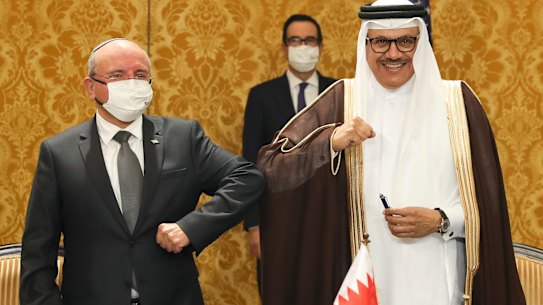 Israel's national security adviser, Meir Ben-Shabbat (left) bumps elbows with Bahrain's Foreign Minister Abdullatif al-Zayani after signing an agreement in Manama, Bahrain, on Sunday.