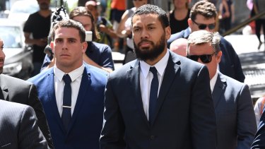 NRL players Adam Elliott and Asipeli Fine leave the Downing Centre Court on Monday. 