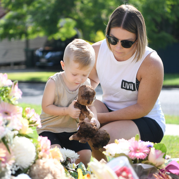 Chantel Taylor and her two year-old son Henley pause after placing teddybears at a makeshift shrine near the scene of the murders.
