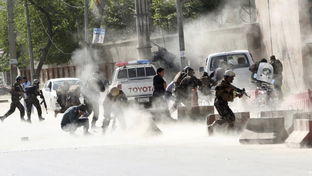 Security forces run from the site of a suicide attack after the second bombing in Kabul.