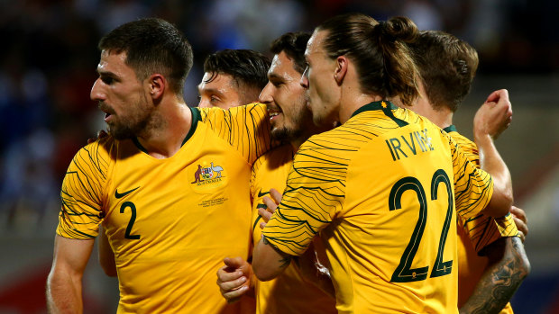 Matthew Leckie of Australia, centre, celebrates with teammates after scoring the Socceroos' opening goal against Kuwait.