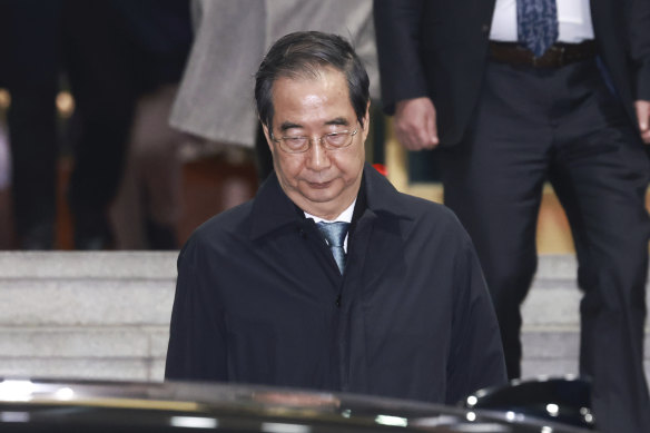 Impeached South Korean acting President Han Duck-soo leaves the government complex building in Seoul.