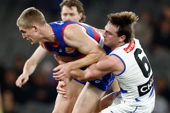 Tim English wrapped up in a tackle by George Wardlaw.