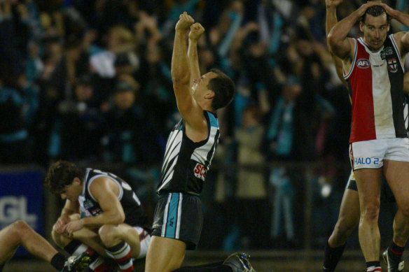 Port Adelaide’s Warren Tredrea celebrates as St. Kilda’s Stephen Powell and Robert Harvey are devastated.