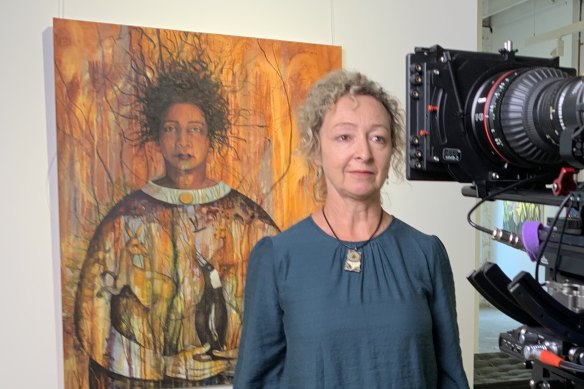 Artist Penny Lovelock, in front of one of her paintings, Out of the ashes, while filming We are Conjola.
