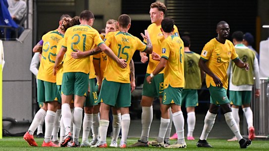 Australia’s players celebrate Japan’s own goal at Saitama Stadium.