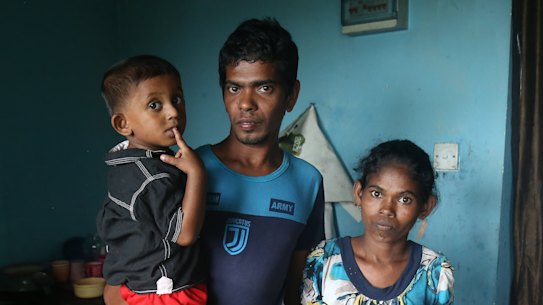 Sandun Rohitha with his wife Niluka and son Yenura. Without gas for the past eight months, they have been using firewood and plastic sheets to cook. “I can’t bear the sadness,” Sandun says.