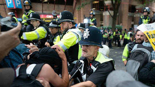 Mounted police officers scuffle with demonstrators during a protest by anti-migrant Abolish Asylum System and counter protesters at Castle Park in Bristol, England.