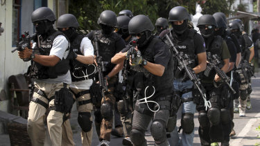 Indonesian police anti-terror unit Special Detachment 88 move into positions as they prepare for a raid.