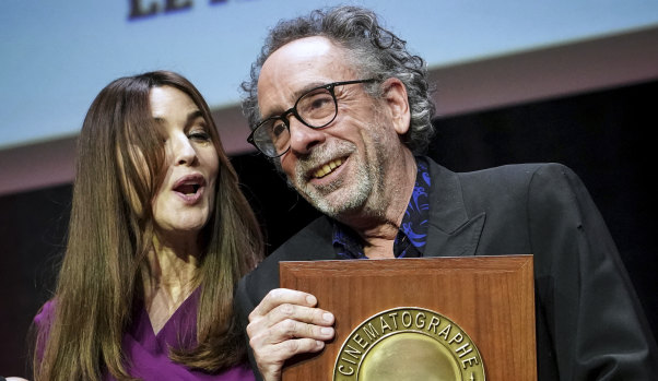Director Tim Burton with the award he won at the Lumiere Festival in Lyon, with presenter Monica Bellucci.