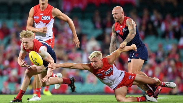 Contest: Melbourne's Clayton Oliver tussles with Swan Isaac Heeney.
