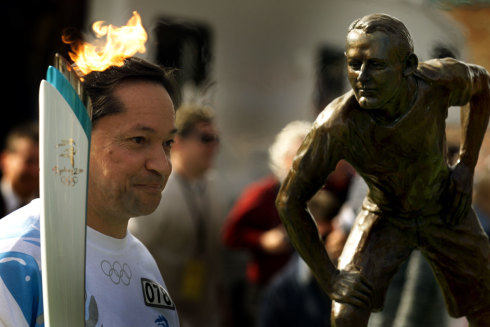 A statue of Australia’s first Olympic winner Edwin Flack looks over the shoulder of torch-bearer Alain Cerdor before the Sydney 2000 Olympics.