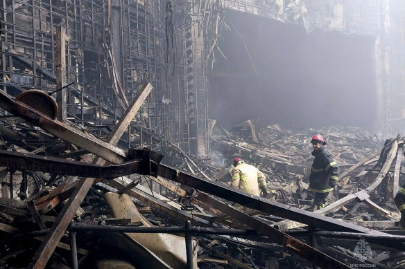 Russian emergency services personnel search through debris at the Crocus City Hall in Moscow.