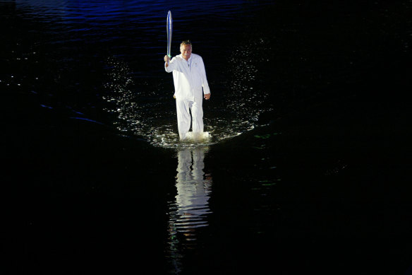 Barassi carries the Queen’s Baton while “walking on water” across the Yarra River for the opening ceremony of the 2006 Commonwealth Games in Melbourne.