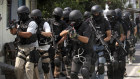 Members of the Indonesian police anti-terror unit Special Detachment 88 move into positions as they prepare for a raid.