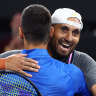 Nick Kyrgios and Novak Djokovic embrace after winning their first doubles match.