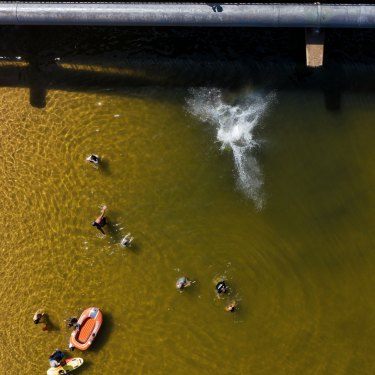 Kids jump from the North Narrabeen Bridge in Sydney during a heatwave in January 2021.