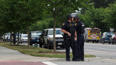 Virginia Beach Police Officers huddle near the intersection of Princess Anne Road and Nimmo Parkway following a shooting at the Virginia Beach Municipal Centre.