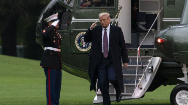 President Donald Trump salutes as he steps from Marine One at the White House as he returns from Bedminster on Thursday after a fundraiser.
