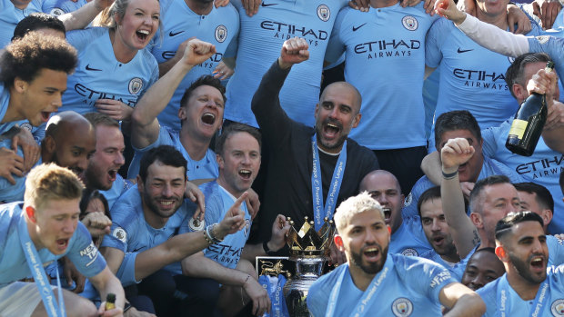 Manchester City boss Pep Guardiola celebrates winning last season's Premier League title with his team.