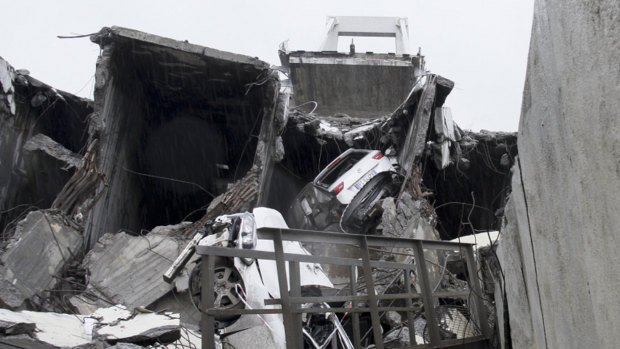 Cars are seen among the rubble of the collapsed bridge.