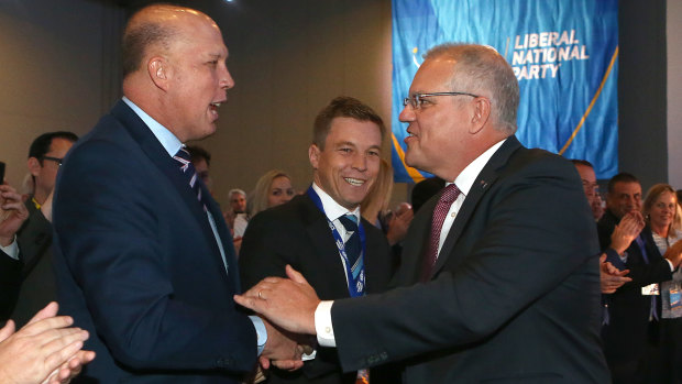 Prime Minister Scott Morrison pauses to shake hands with Home Affairs Peter Dutton at the QLD LNP convention.