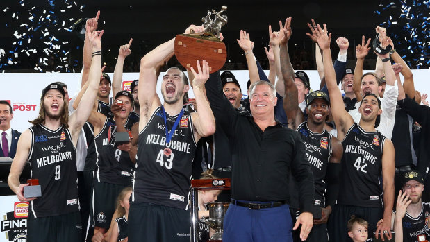 United in victory: Chris Goulding with coach Dean Vickerman and the Melbourne team after their breakthrough NBL title win.