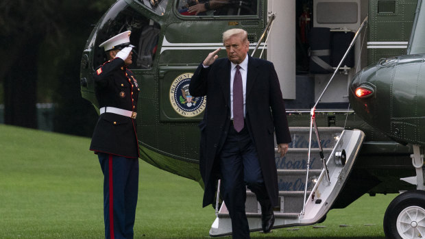 President Donald Trump salutes as he steps from Marine One at the White House as he returns from Bedminster on Thursday after a fundraiser.