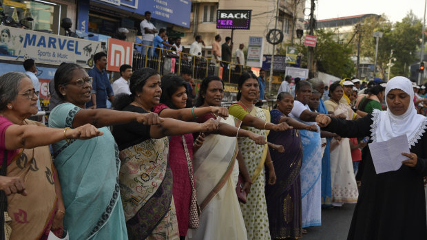 Women raise their hands to take a pledge to fight gender discrimination as they form part of a hundreds kilometre long "women's wall" in Thiruvananthapuram, in the southern Indian state of Kerala on January 1.
