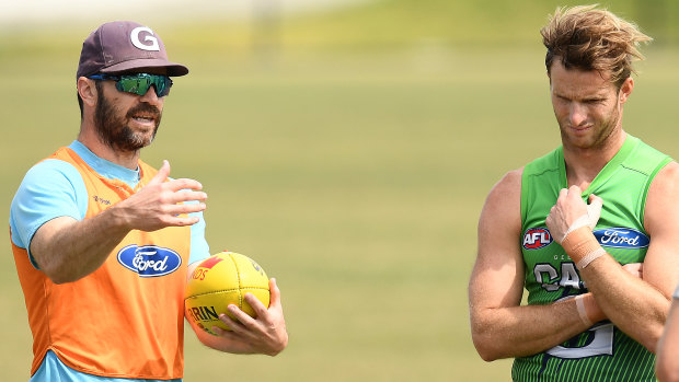 Matthew Scarlett (left) imparts some words of wisdom to Cats defender Lachie Henderson at training.