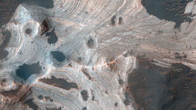 Much of Mars is covered by sand and dust but in some places, such as Holden Crater, stacks of sedimentary layers are visible.