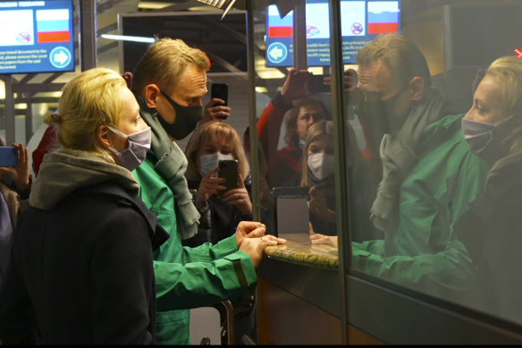 In this grab taken from video, Alexei Navalny and his wife Yulia stand at the passport control before Navalny was detained by police after arriving at Sheremetyevo airport, outside Moscow.