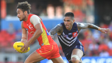 Tear-away: Gold Coast's Jarrod Harbrow breaks past Fremantle's Michael Walters.