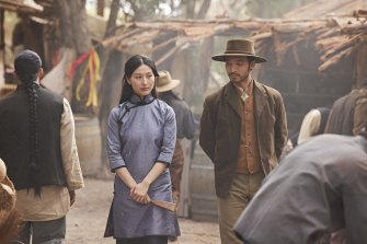 Shing strolls through the Chinese camp with Zhang Lei (Mabel Li), who represents the interests of the shadowy and powerful Brotherhood.