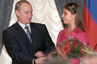 Vladimir Putin hands flowers to Alina Kabayeva, Russian rhythmic gymnastics star and Olympic medal winner, in 2001. 