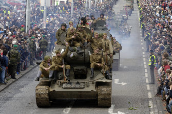 프라하에서 열린 군사 퍼레이드에 참여하고있는 적군 제복을 입은 군사 역사 클럽의 회원들과 함께 소련이 만든 T-34 탱크.