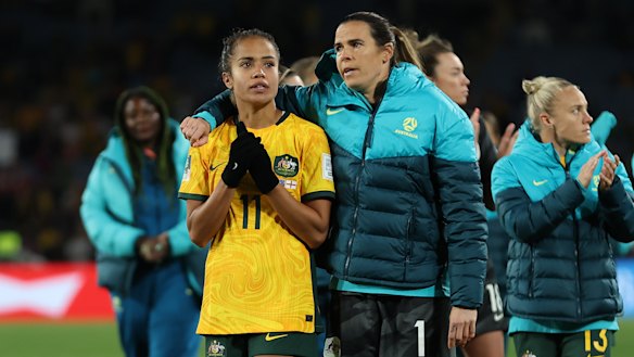 Mary Fowler of Australia is embraced by Lydia Williams as players of Australia applaud the fans after defeat to England.