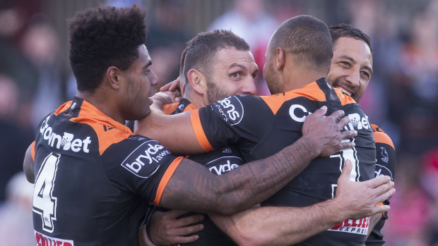 Old firm: Robbie Farah and Benji Marshall join a Tigers huddle after a try to Luke Brooks.
